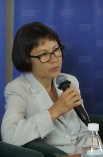 Kobieta w okularach trzymająca mikrofon w ręku